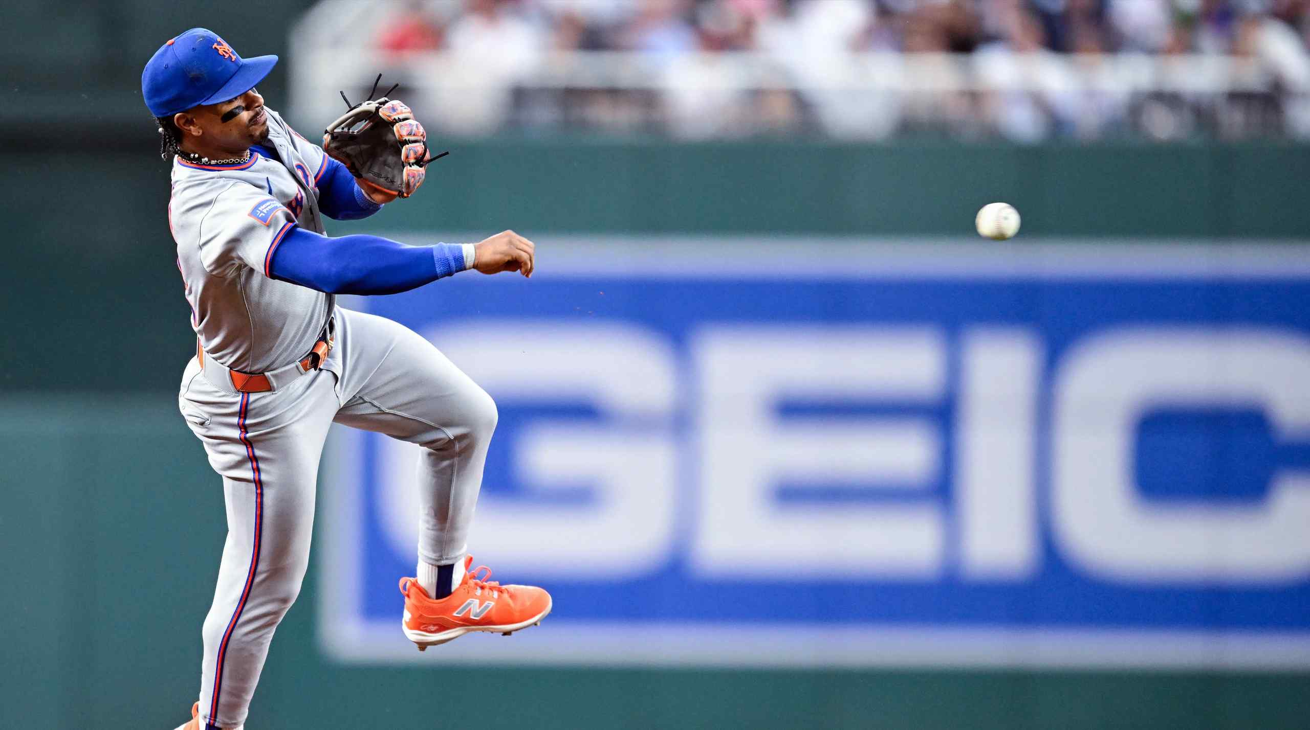 A New York Mets player throwing a ball.